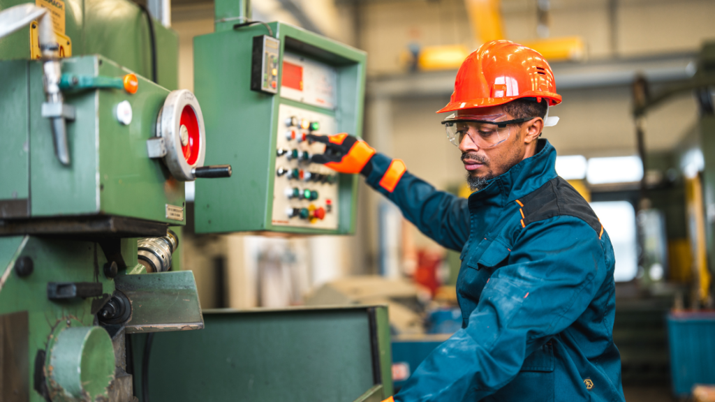 Employee working a punch press utilizing safety equipment including time based brake monitoring and e-stops.