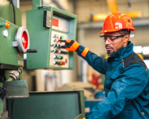 Employee working a punch press utilizing safety equipment including time based brake monitoring and e-stops.