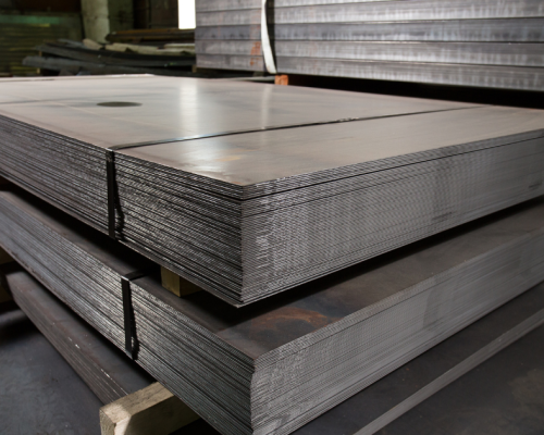 Sheets of metal in a stamping press, highlighting the importance of tonnage monitoring for precision, press safety, and efficient metal stamping.